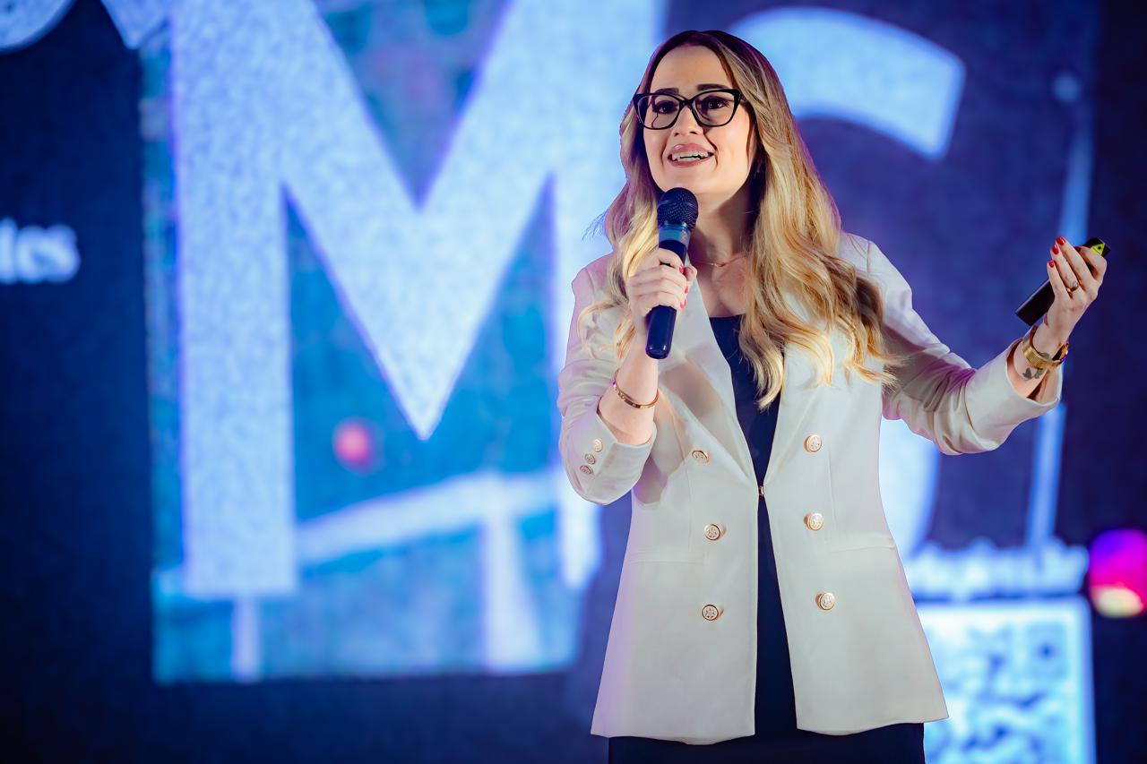 Carla Pires falando ao público em um evento